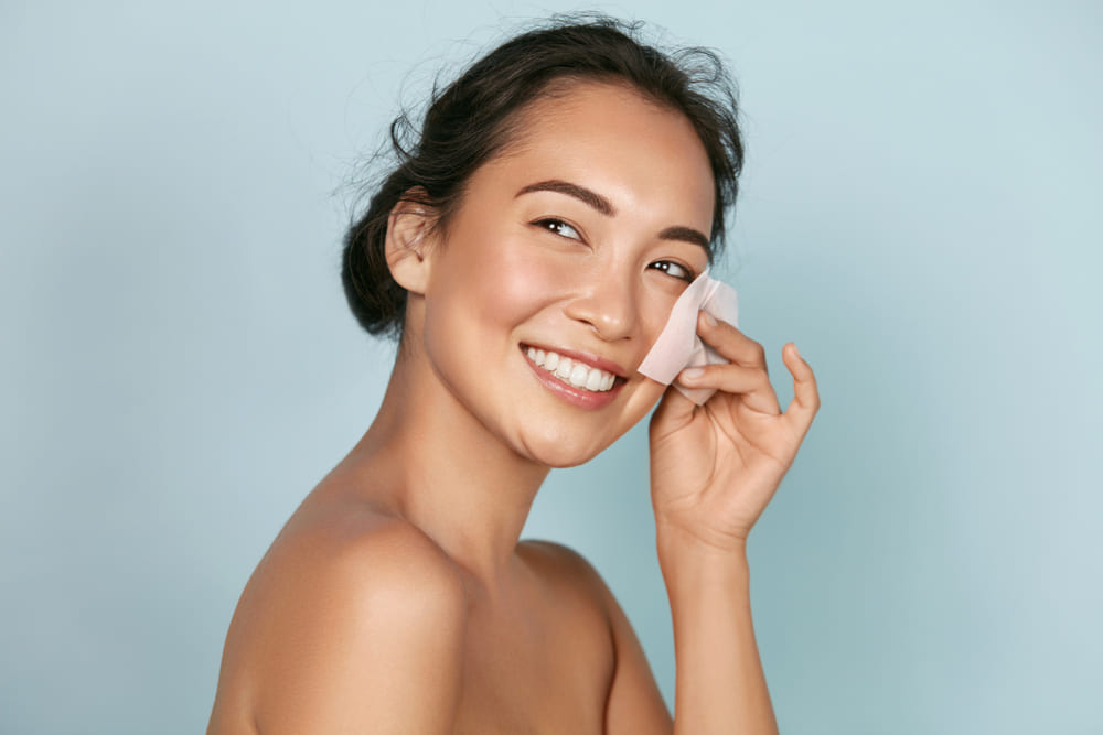 Woman using a skin blotting sheet to find out her skin type