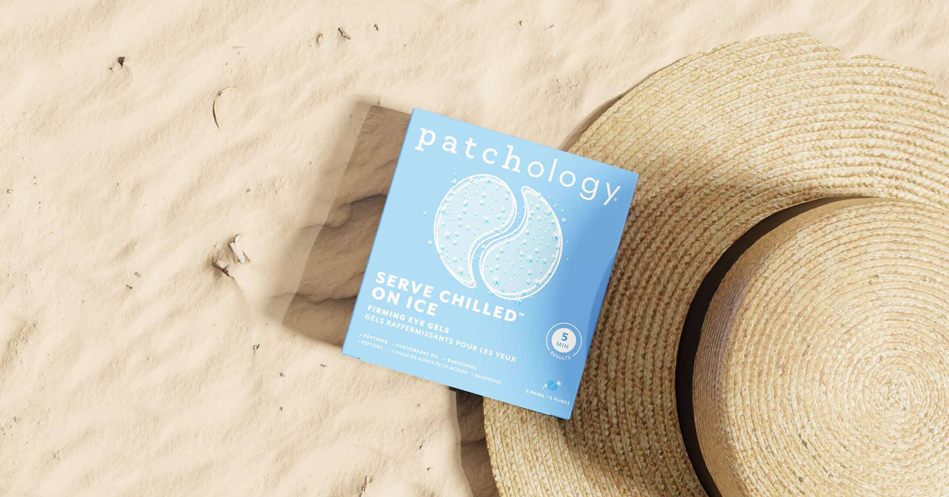 on ice eye patches on the sand in the summer at the beach with a straw hat