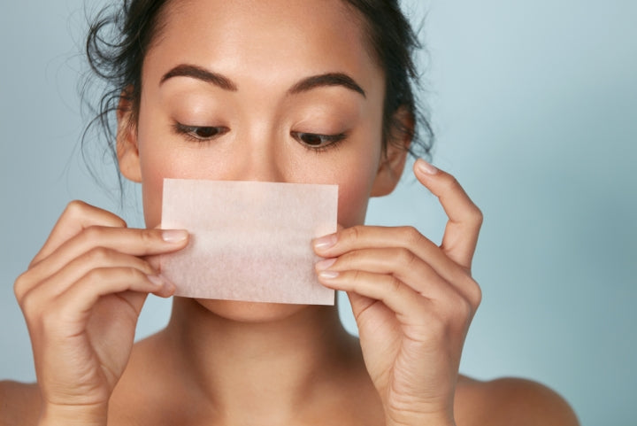 Woman with oily skin holding a cleansing wipe