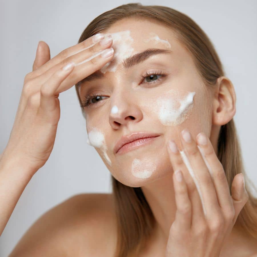 woman featuring her morning skincare routine of cleanser, under eye gels, moisturizer, toner and sunscreen