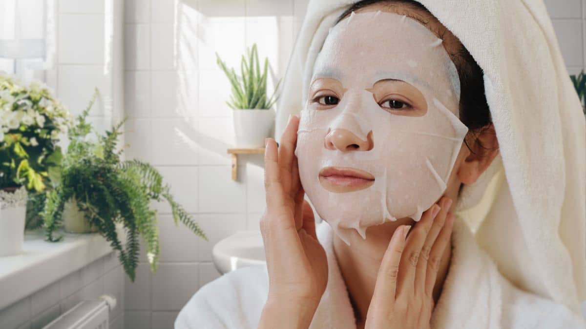 woman wearing hydrating patchology sheet mask to brighten and add moisture to her skin