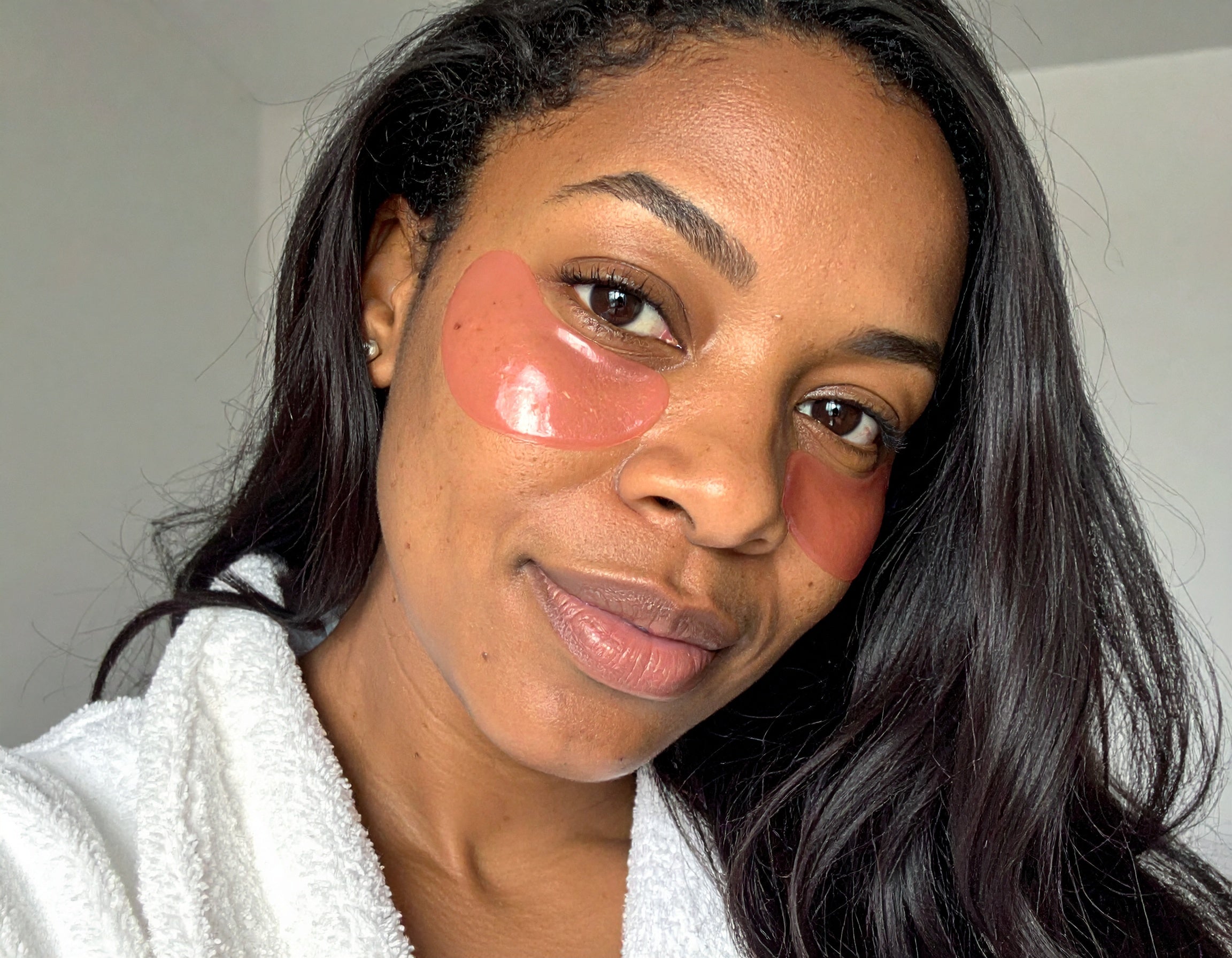 Woman with pink patches on her cheeks wearing a white robe.