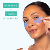 Smiling woman pressing blue gel patches under her eyes, with text reading hydrating and cooling skincare kit on a pale blue background