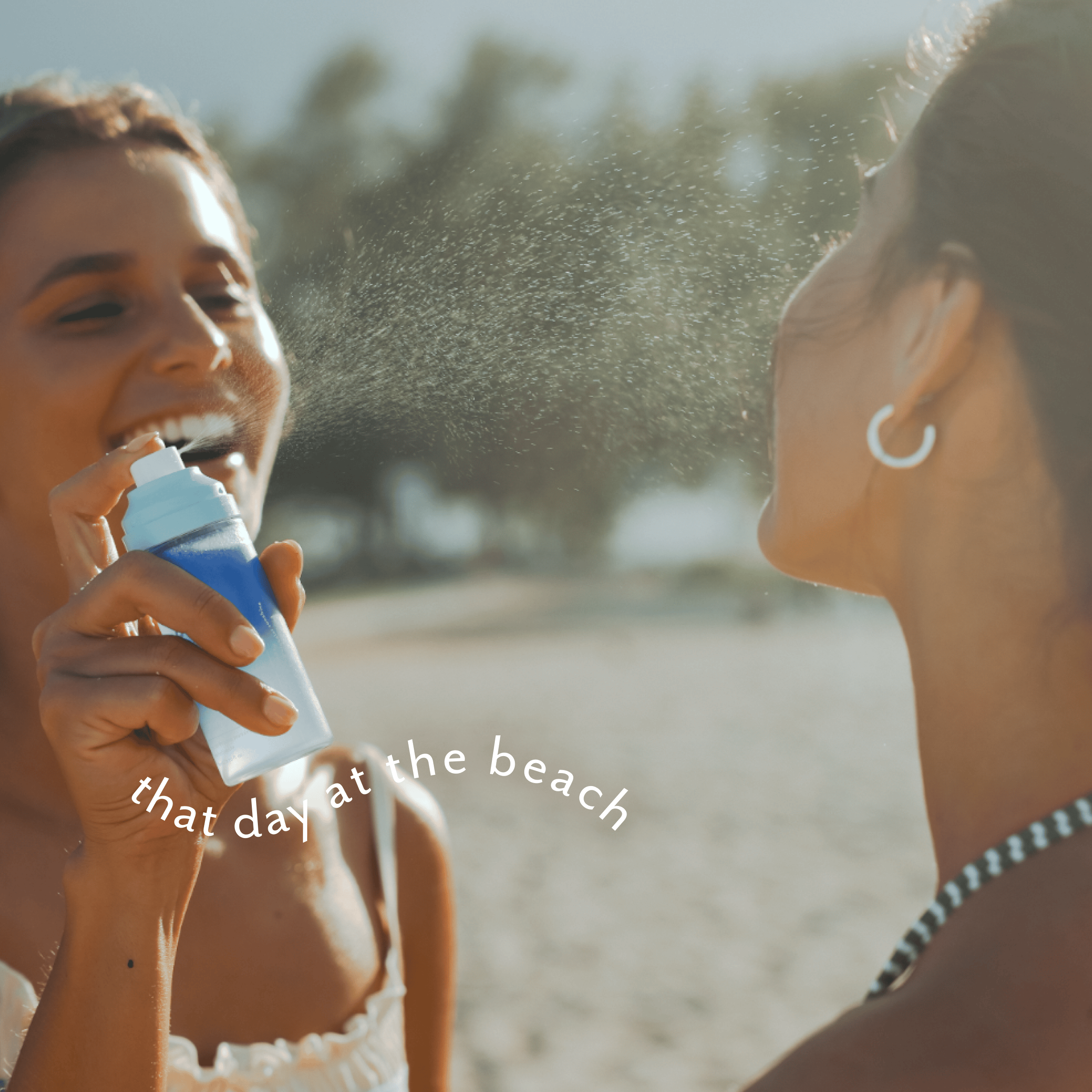 Two women on a beach spraying each other with a blue and white sunscreen bottle, with the text 'that day at the beach' overlaid on the image.