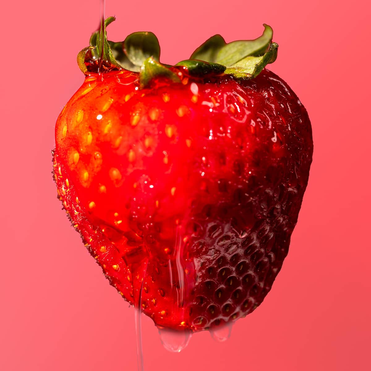 Strawberry with water droplets on a pink background