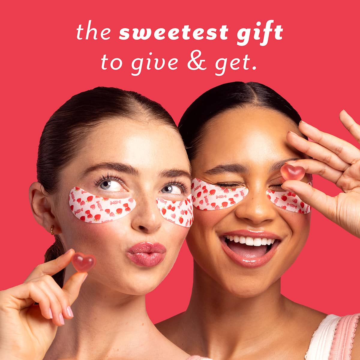 Two women wearing red and white patterned eye masks with a pink background and text 'the sweetest gift to give & get'.
