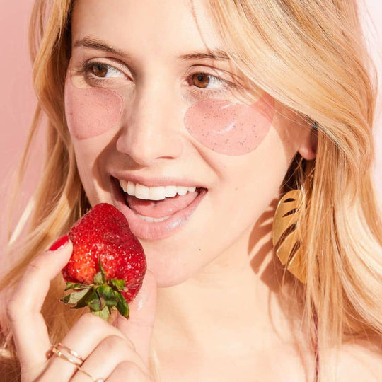 Woman wearing rose eye gels eating a strawberry serve chilled eye gels
