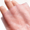 close up hands holding renewing rosé sheet mask light pink serve chilled