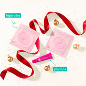 Pink lip balm packaging with red ribbons and gold ornaments on a white background text highlights the benefits. Hydrates under eye gels and Lip Service smooths and plumps