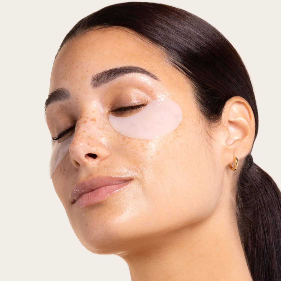 Woman applying a patch under her eye Skin Remedy sensitive skin fragrance free eye patches with a neutral background