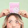 Woman with brown and blonde hair wearing the Happy Place eye gels with rose and hibiscus