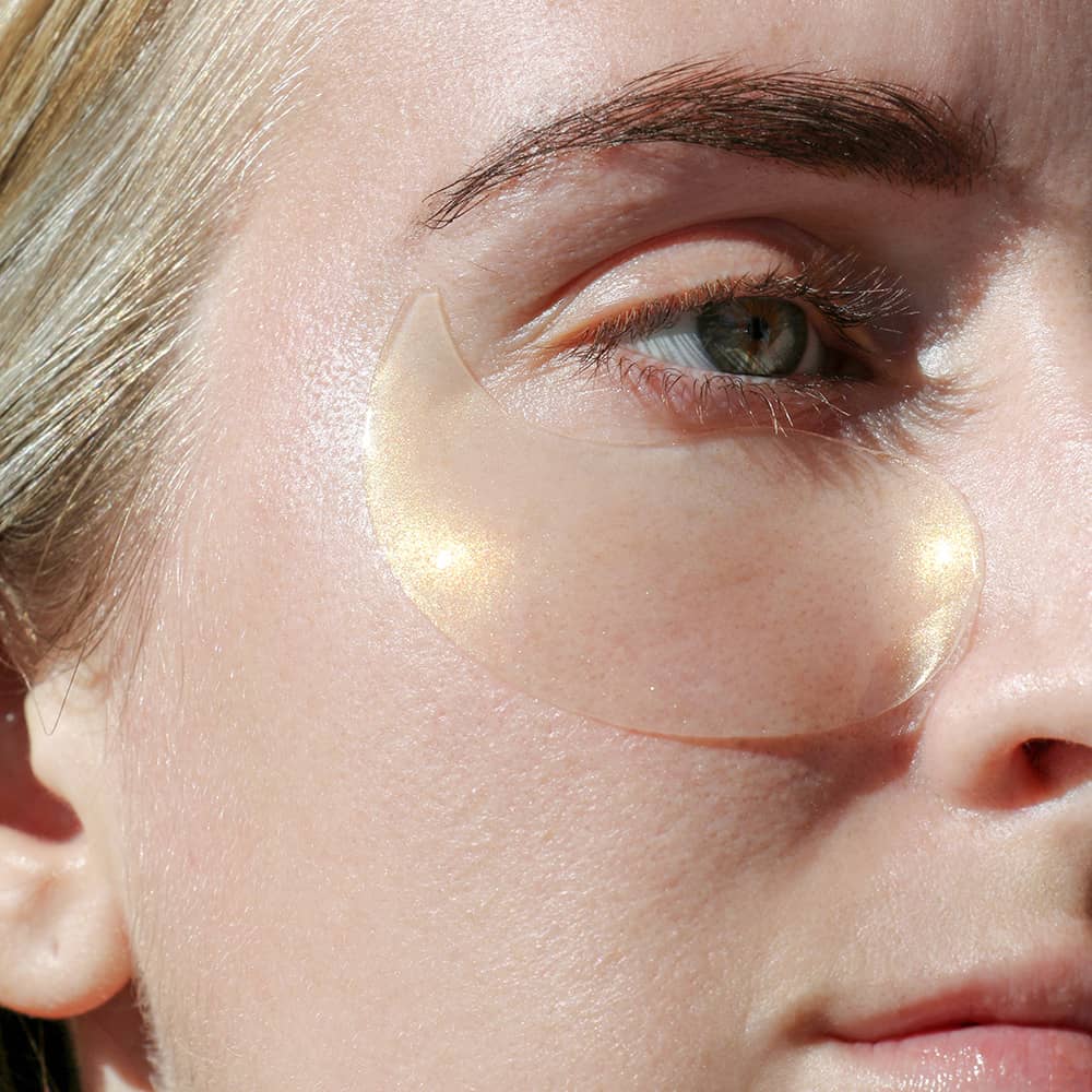 Woman close up wearing the illuminating eye gels bright skin