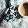 Self-Warming woman wearing hand mask drinking hot chocolate restoring and moisturizing gloves