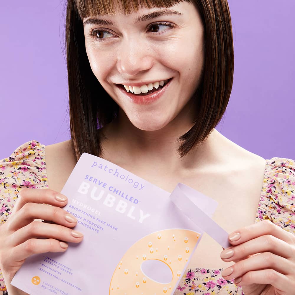Woman opening package of serve chilled bubbly brightening face mask